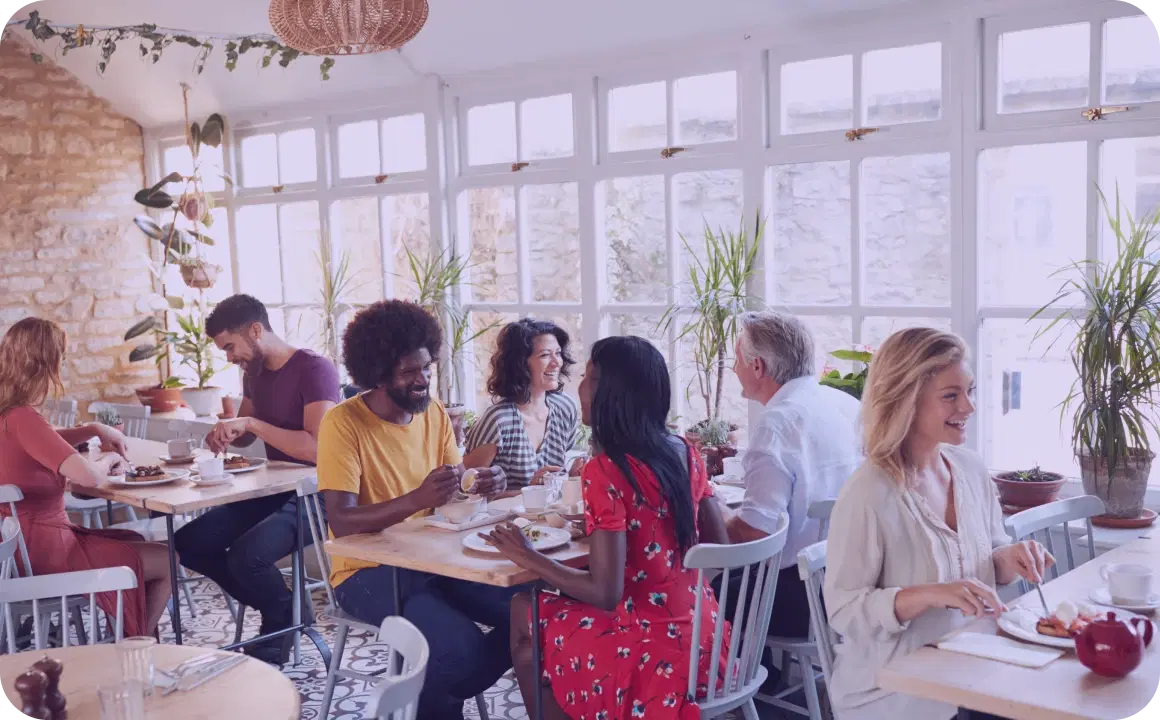 Groupes de personnes déjeunant dans un restaurant utilisant TopMessage pour la communication.