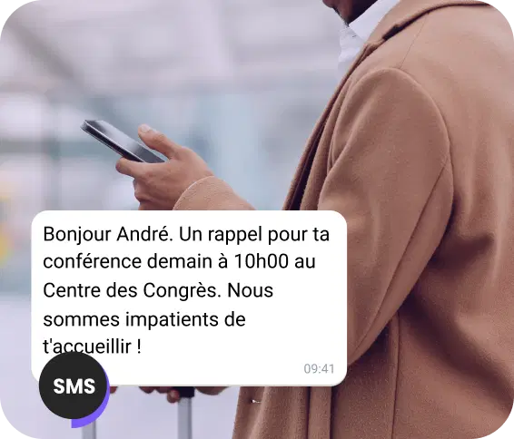 Un homme marche dans la rue en consultant un message SMS pour un rappel de rendez-vous.