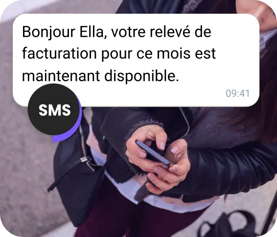 Une jeune femme dans la rue consulte un relevé de facturation envoyé par SMS.