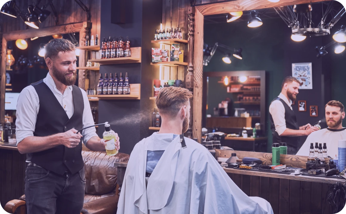 Une cliente souriante se fait couper les cheveux dans un salon de beauté.