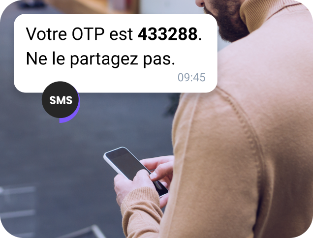 Un homme âgé, dans la neige, consulte son téléphone pour connaître l'emplacement via un message WhatsApp professionnel.