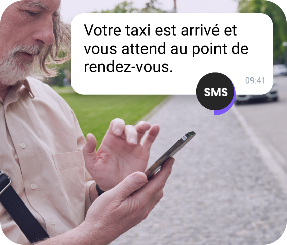 Une jeune femme portant une casquette rouge lit un message professionnel sur WhatsApp sur son téléphone.